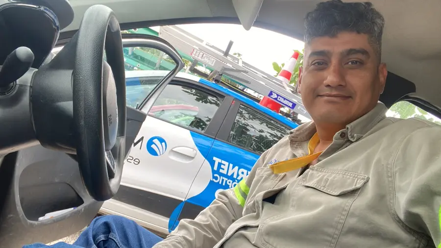 Jorge in the crew vehicle next to a fiber internet service car